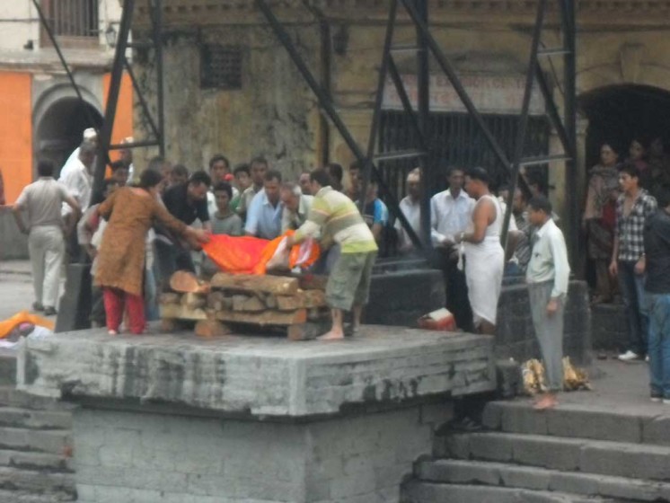Dead body is being placed in a funeral pire in Pashupatinath temple. Hindus are cremated in this famous site.