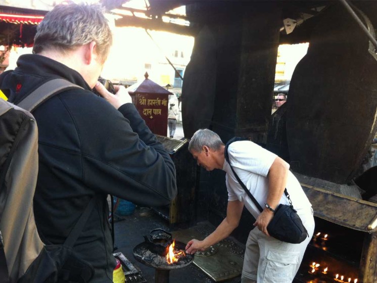Tourist lighting a lamp in Swoyambhunath temple as offering to the god